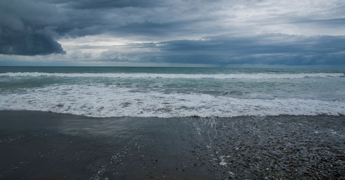Stunning view of a stormy beach with dramatic clouds in New Zealand.